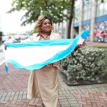 Brandy Rodriguez holdin transgender flag outside